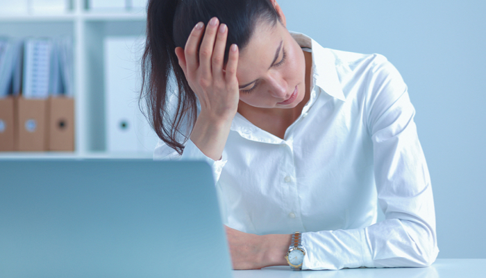 Stressed businesswoman sitting at desk in the office